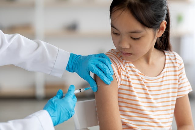 Unrecognizable doctor hands in protective gloves making vaccination against coronavirus of flu for l...