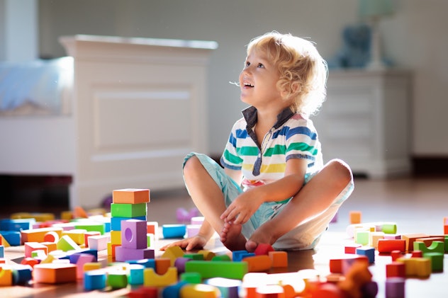 A little boy builds with colorful blocks. Quint is a Q name for a boy.