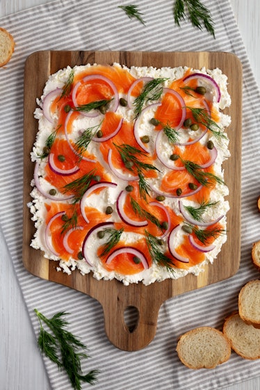 Homemade Cream Cheese Lox Bagel Board with Salmon on a white wooden background, top view. Flat lay, ...