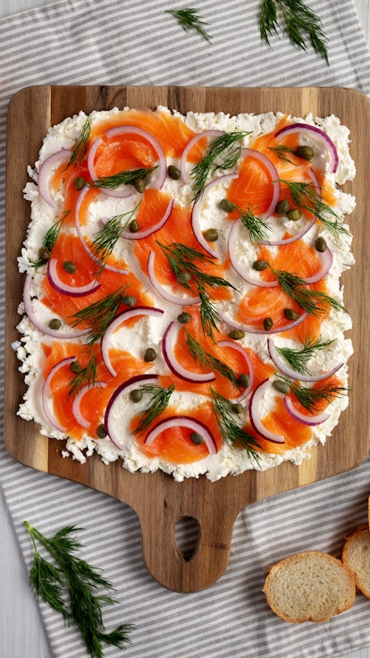 Homemade Cream Cheese Lox Bagel Board with Salmon on a white wooden background, top view. Flat lay, ...