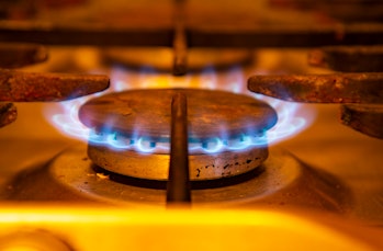 Gas burning with blue flames.  Focus on the front edge of the gas burners.