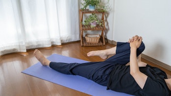 A man stretching at home. Gluteus maximus stretch. lower body stretch. stretch your legs.
