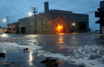 Water rushes down Front Street, just a half block from the Bering Sea, in Nome, Alaska, on . Much of...
