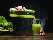 Woman making detox smoothie at home. Green food does the body good