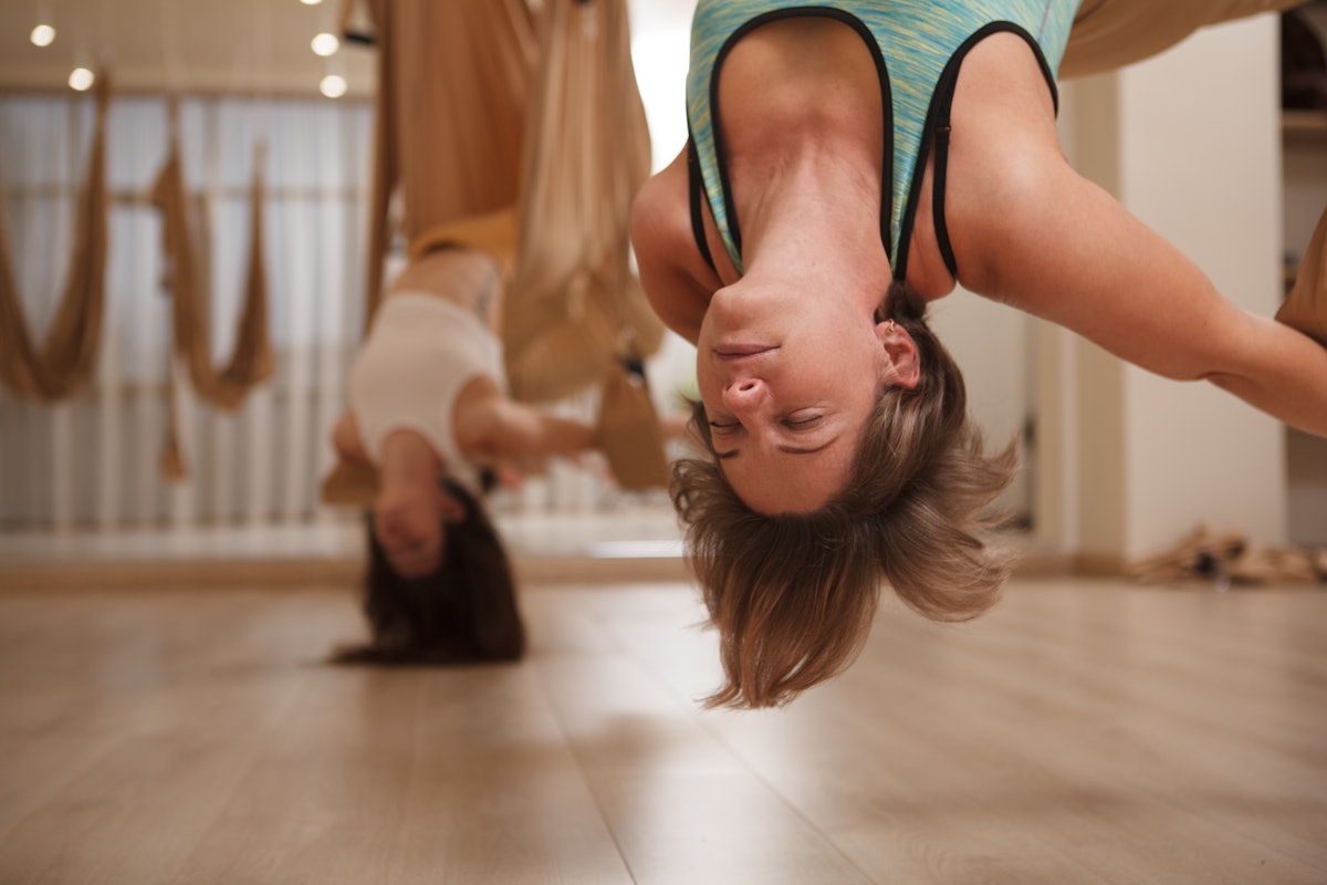 Aerial yoga improves your range of motion by allowing you to do trick yoga poses.