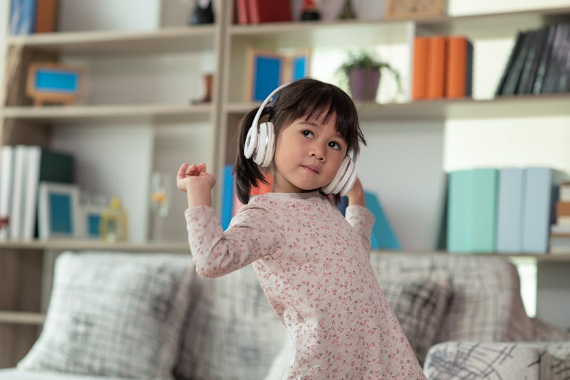 A child wearing headphones in her living room. Xuxa is a unique girl's name that begins with X.