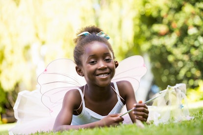 Cute Black girl dressed as a fairy in the park. Fairy names are a lovely option for kids.