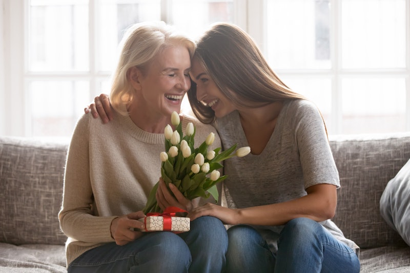 Loving young adult female child congratulate excited elderly mother with birthday anniversary at hom...