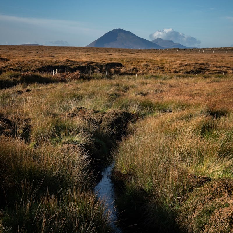 A small stream flows through the moorland of Aughness, Ballycroy, Ireland. On the horizon Slievemore...