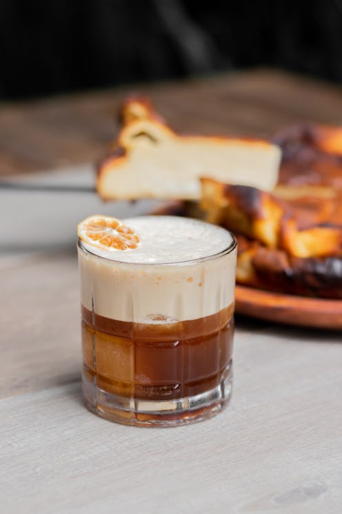 Carajillo drink of liqueurs and cream liqueur on wooden table.