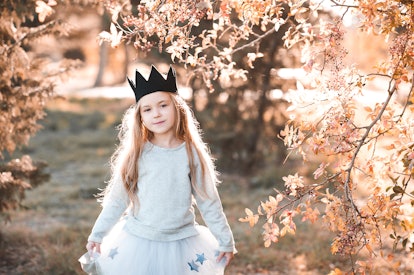 A girl wearing a hand-made crown outside. Some 4 letter girl names have regal meanings.