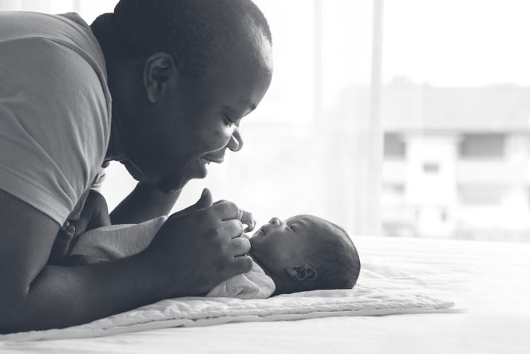 Dad playing with newborn baby.