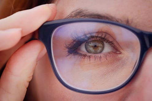 Close-up of a woman's eye with glasses.