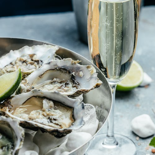 Fresh oysters with lemon and ice. Restaurant delicacy. oysters dish. Oyster dinner with champagne in...