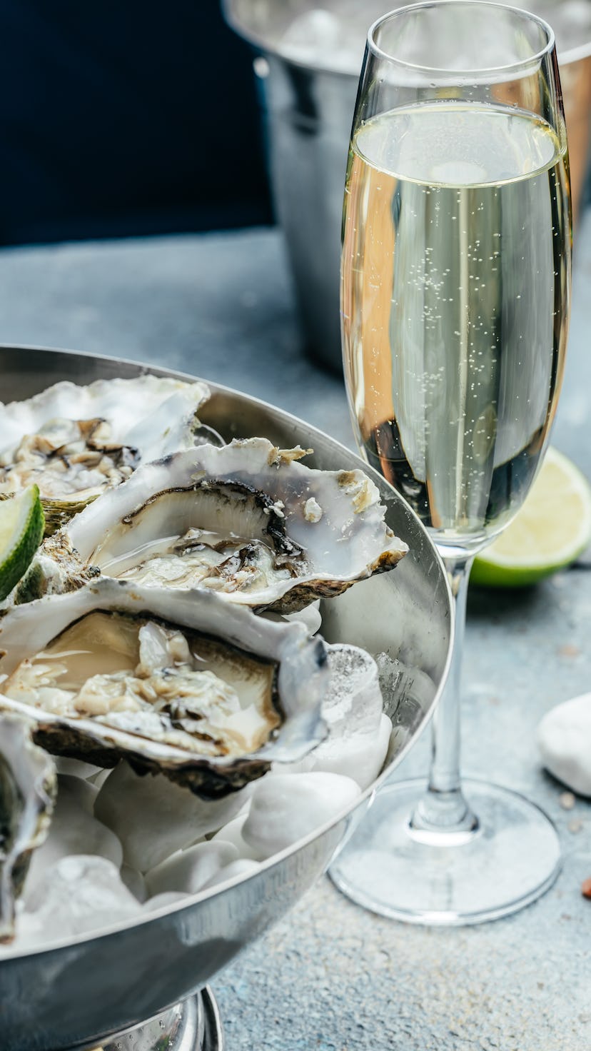 Fresh oysters with lemon and ice. Restaurant delicacy. oysters dish. Oyster dinner with champagne in...