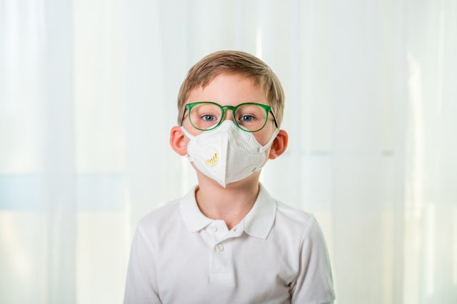 Child boy in face mask is going to school. Protection for kids.