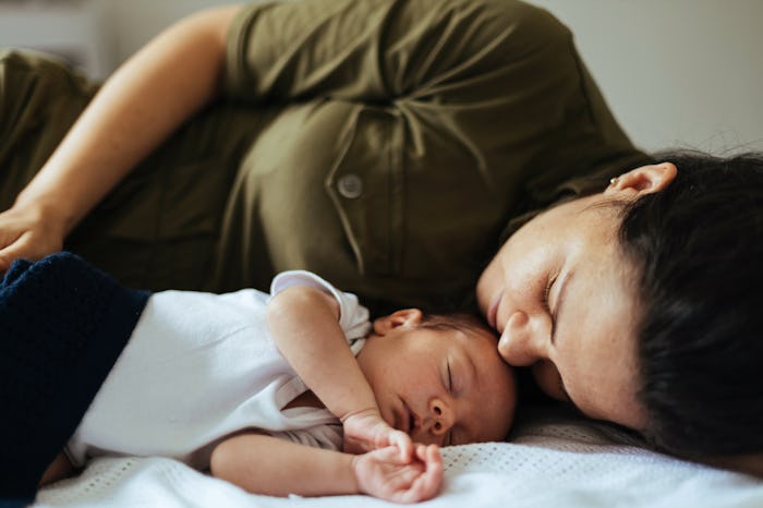 A mother and new born baby taking a nap together in article about adjusting baby to DST