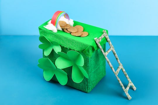 DIY leprechaun trap with gold coins, rainbow and green ladder St Patricks Day background. Gift Idea,...