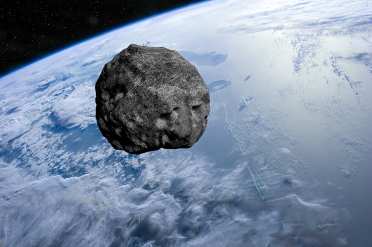Planet Earth and big asteroid in the space. Asteroid in outer space near Earth planet. Meteorite on ...