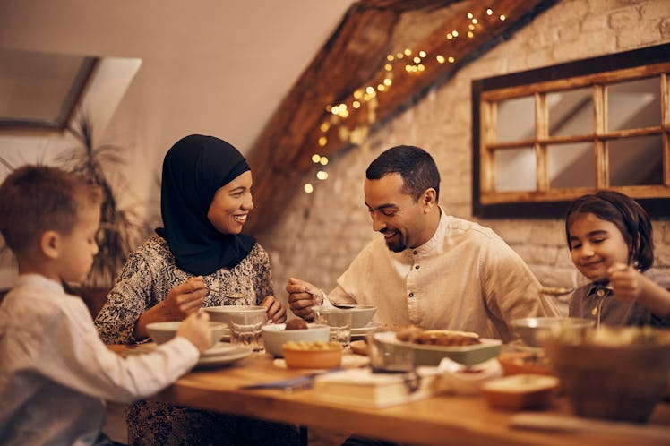 Happy family eating a meal at a dining table at home.