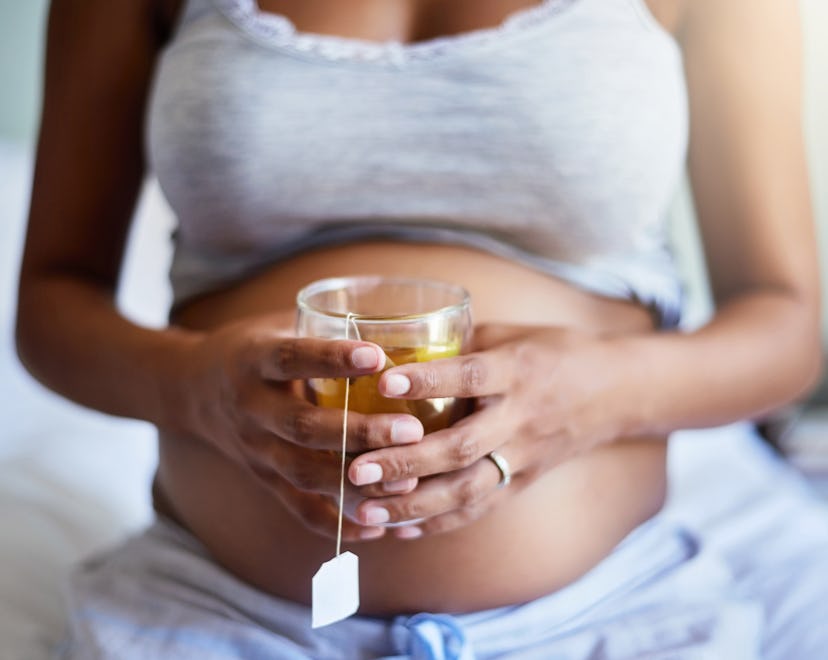 Is chamomile tea safe during pregnancy? Cropped shot of a pregnant woman relaxing at home with a gla...