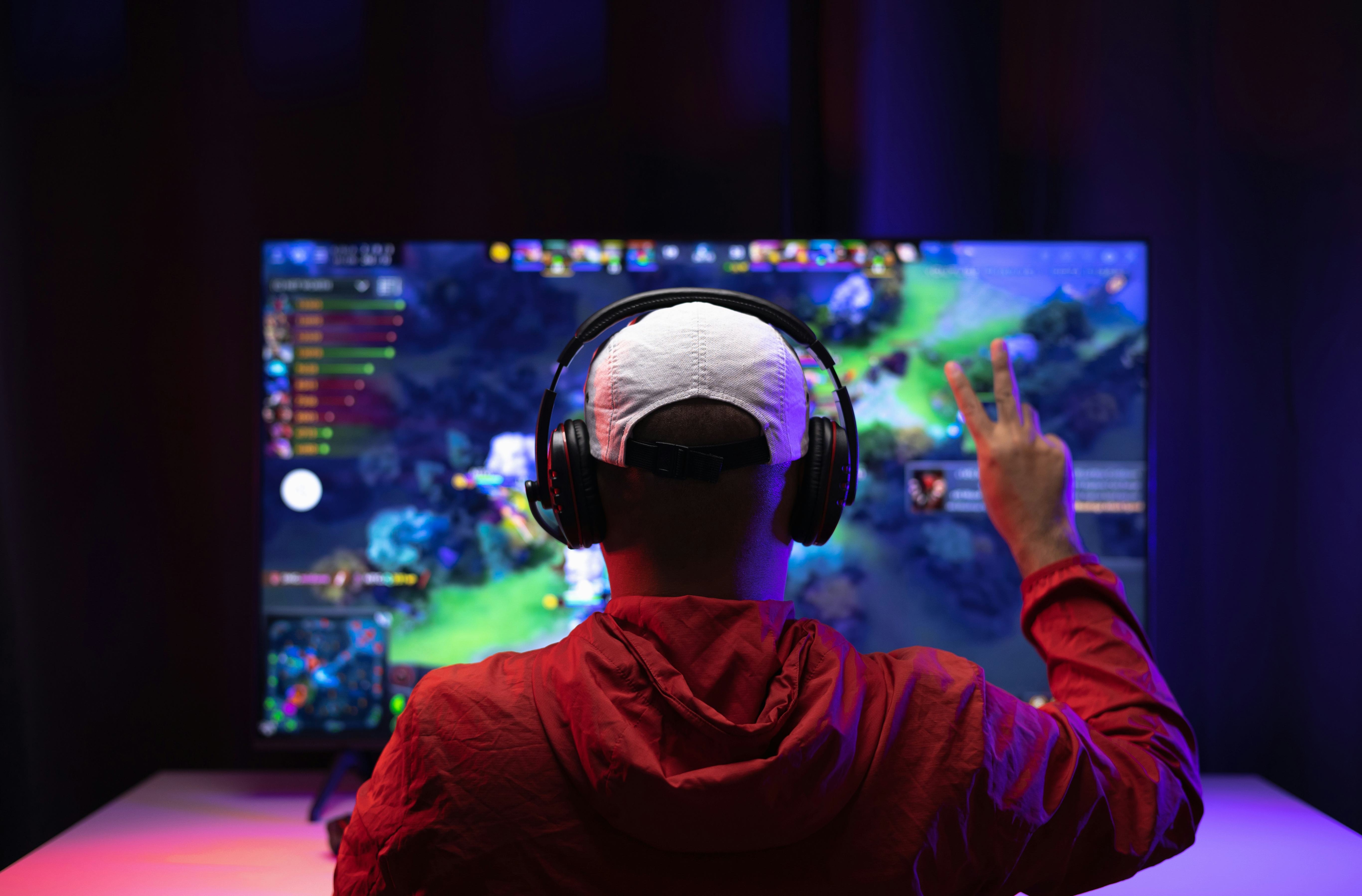 Rear view young Player video computer pc. Young man sitting on chair in game station.Streamer man we...