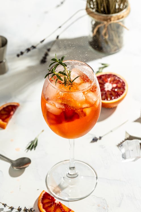 Italian Aperol Spritz cocktail with with bloody oranges, red bitter, dry white wine, soda, zest and ...