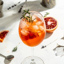 Italian Aperol Spritz cocktail with with bloody oranges, red bitter, dry white wine, soda, zest and ...