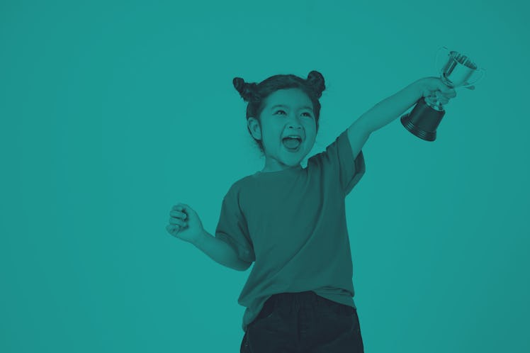 A little Girl Smiles with a Trophy in Her Hands Isolated on White Background. North Carolina GOP law...