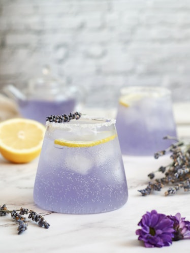 Glasses of fresh sparkling lavender-lemonade soda drink with salt&sugar on the edge of glass,healthy...