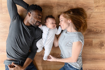 A family portrait of a man, woman, and baby.