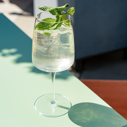 Single glass with iced summer lemonade with mint leaf on the table