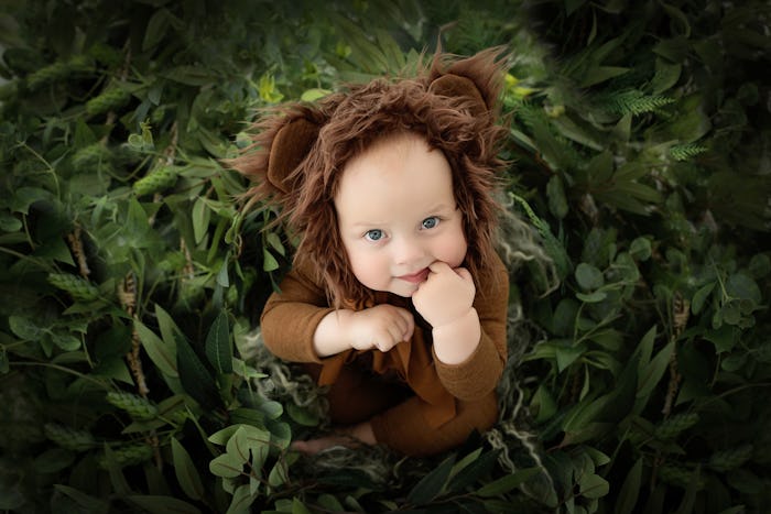 A CHILD DRESSED AS A BEARS IN GREEN PLANTS in an article on animal baby names.