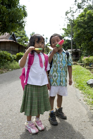 Girl and boy eating ice cream in a street in Rantepao, Sulawesi, Indonesia, Southeast Asia
