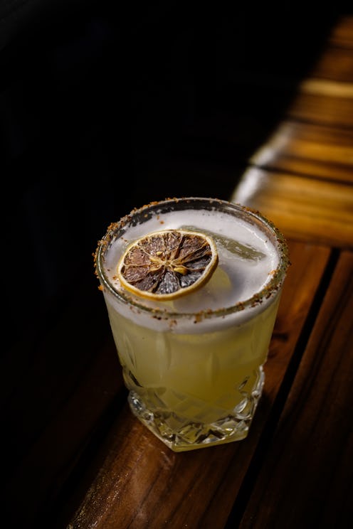 Mezcal cocktail with fruit and seasoning on a bar table in Mexico