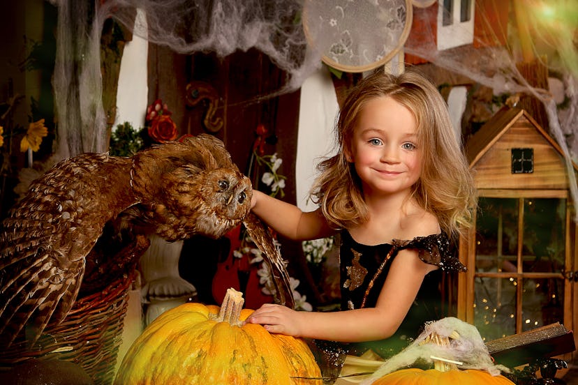 Little girl in a magical outfit in Halloween decorations