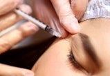 Botox injection close-up of the face, the background is blurred, injections to smooth out wrinkles, ...