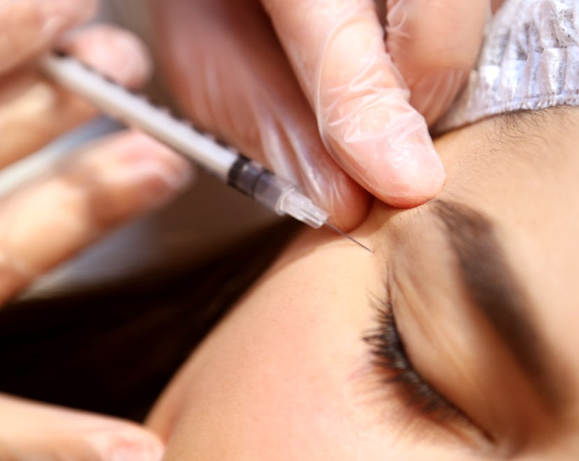 Botox injection close-up of the face, the background is blurred, injections to smooth out wrinkles, ...