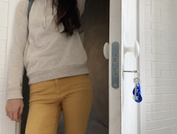 Woman stands in the doorway with bunch of keys in the keyhole