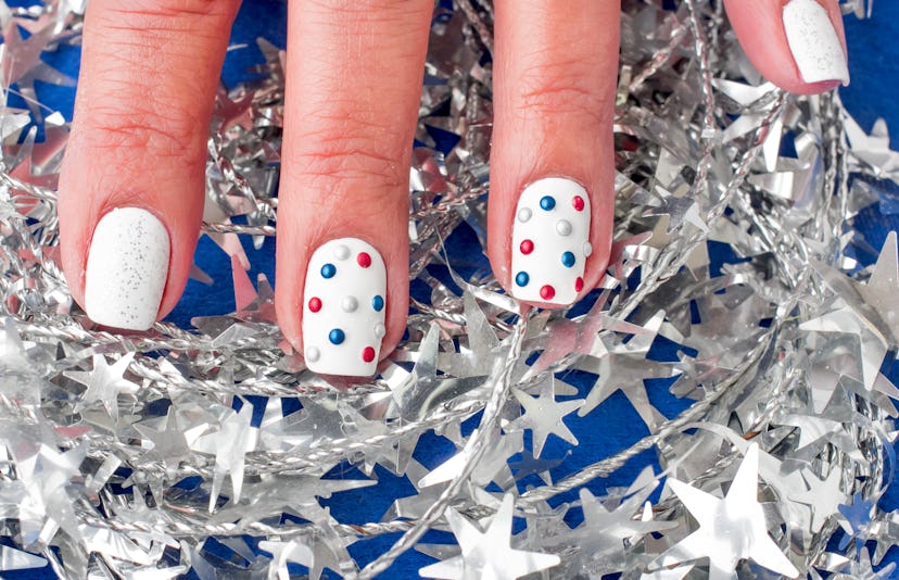 A white Fourth Of July nail design set with polka dots.