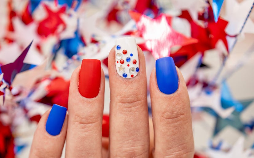 A Fourth of July nail design with jeweled accents.