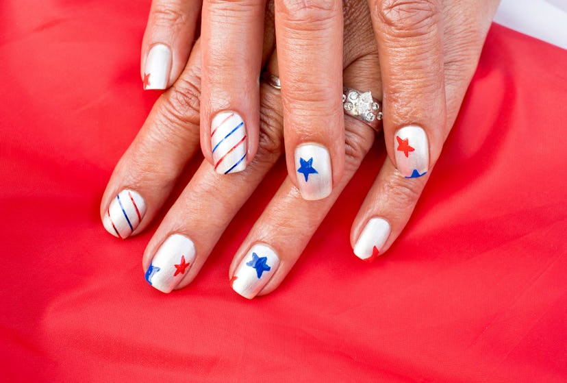 Silver Fourth of July nails with red, white, and blue stars and stripes.