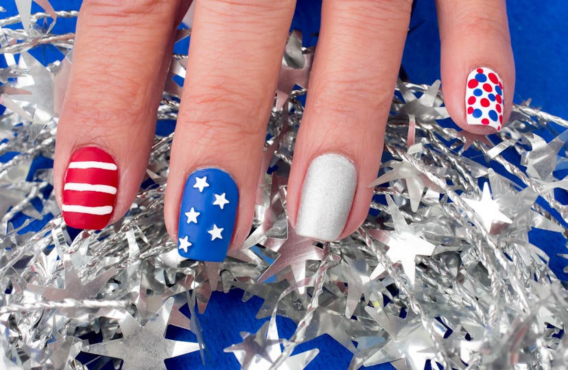 A Fourth of July nail design with stars, polka-dots, and stripes.