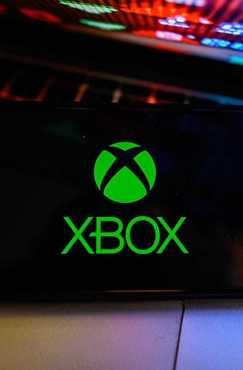 In this photo illustration, a Xbox logo is displayed on a smartphone with stock market percentages o...