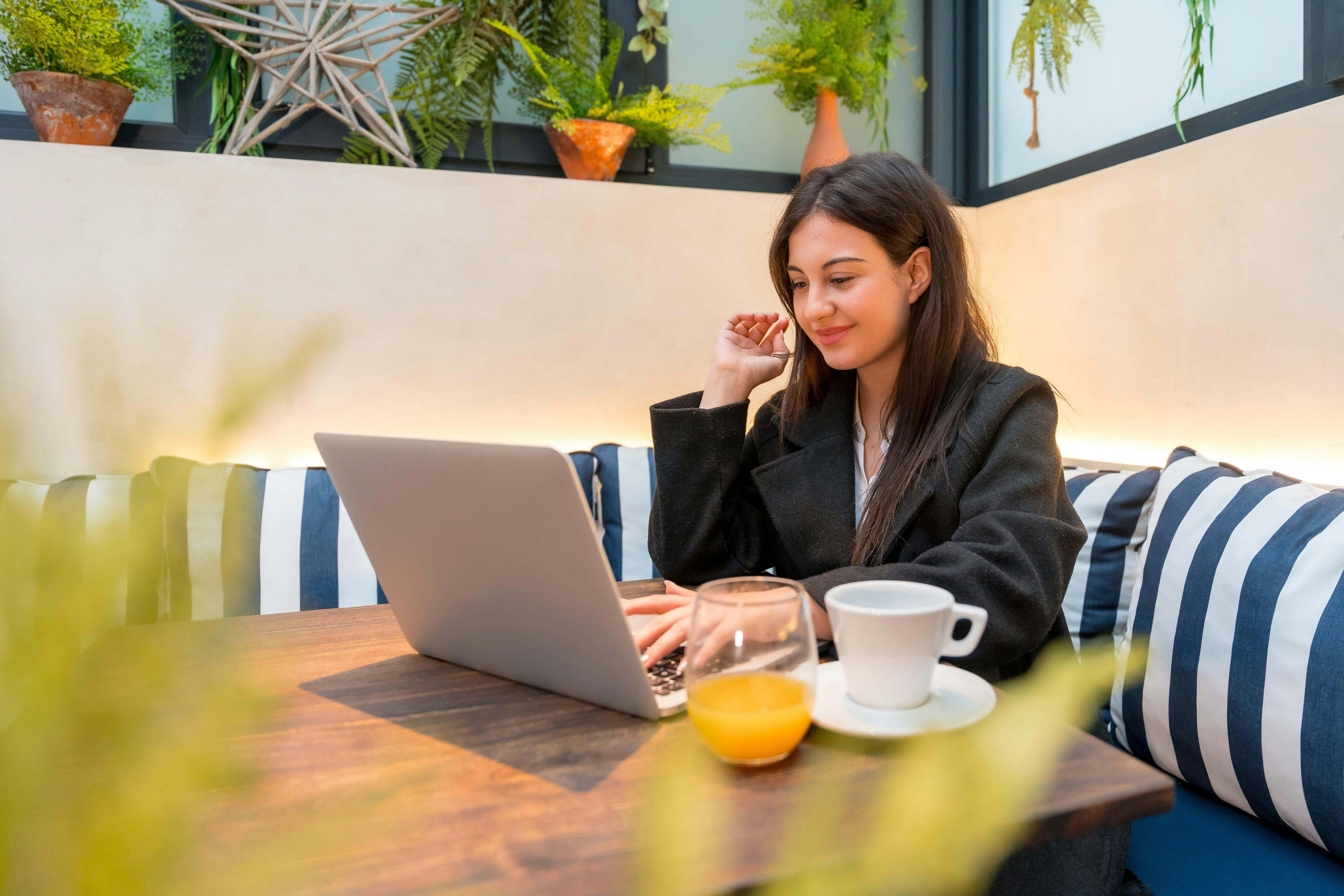 Young businesswoman using laptop in a cafeteria