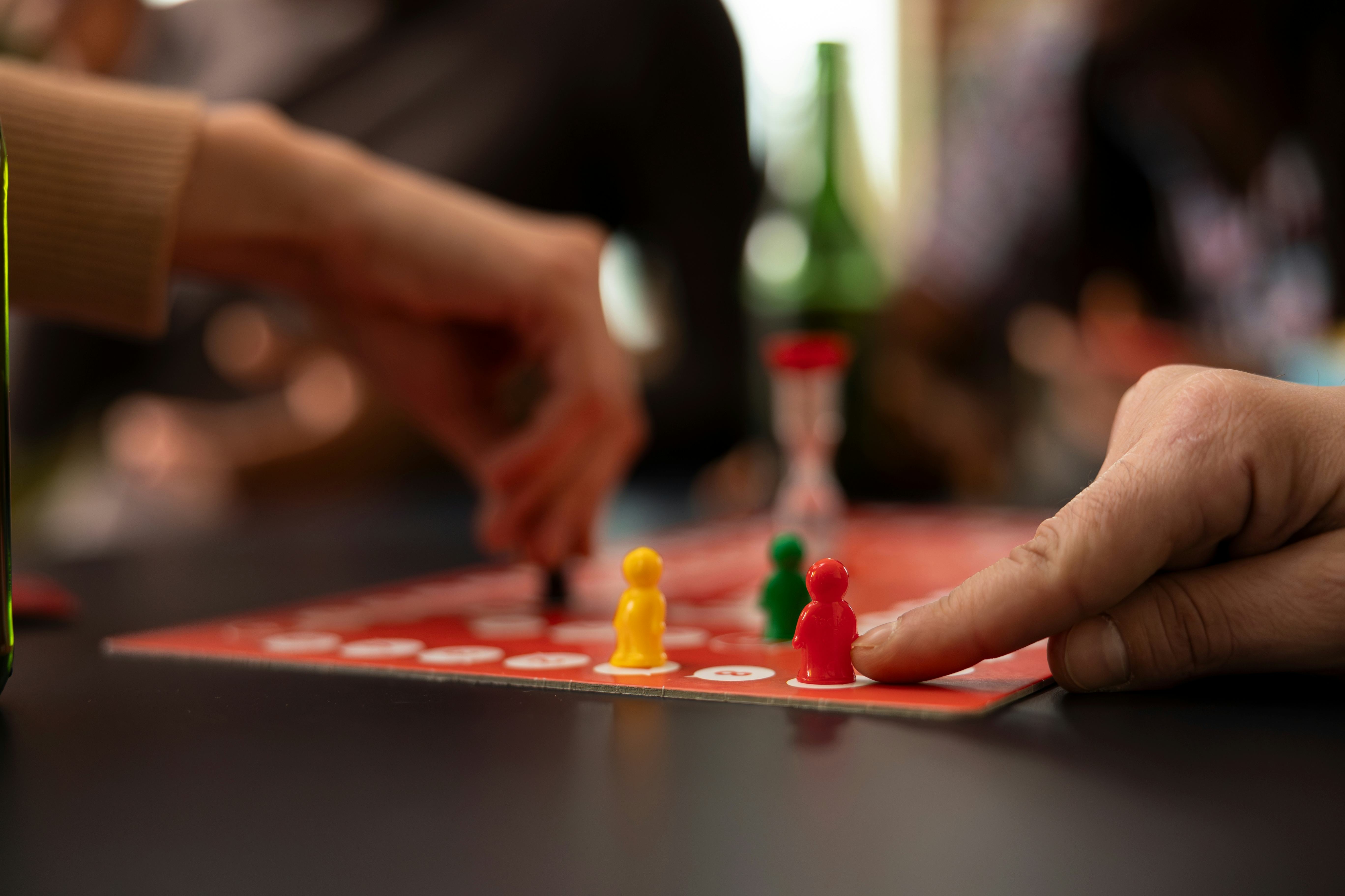 Closeup shot of caucasian finger moving a red piece on board. The image captures moment of strategic...