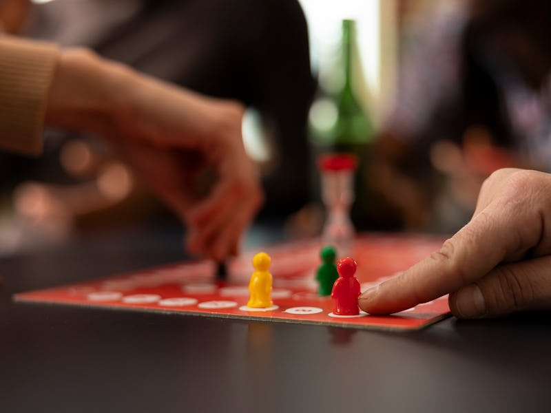Closeup shot of caucasian finger moving a red piece on board. The image captures moment of strategic...