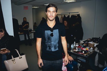 Andrew Warren posing for a photo in the backstage of a fashion week