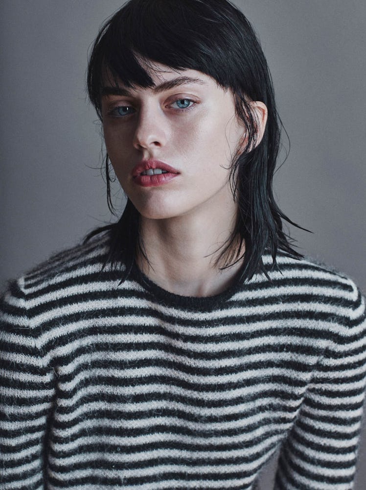 Sarah in a black and white striped sweater posing for a shoot