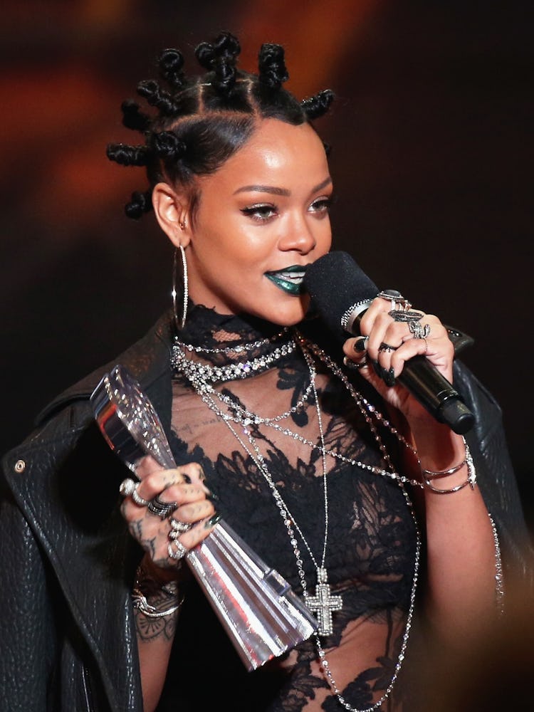 Rihanna giving a speech at the 2014 iHeartRadio music awards wearing bantu knots and green metallic ...
